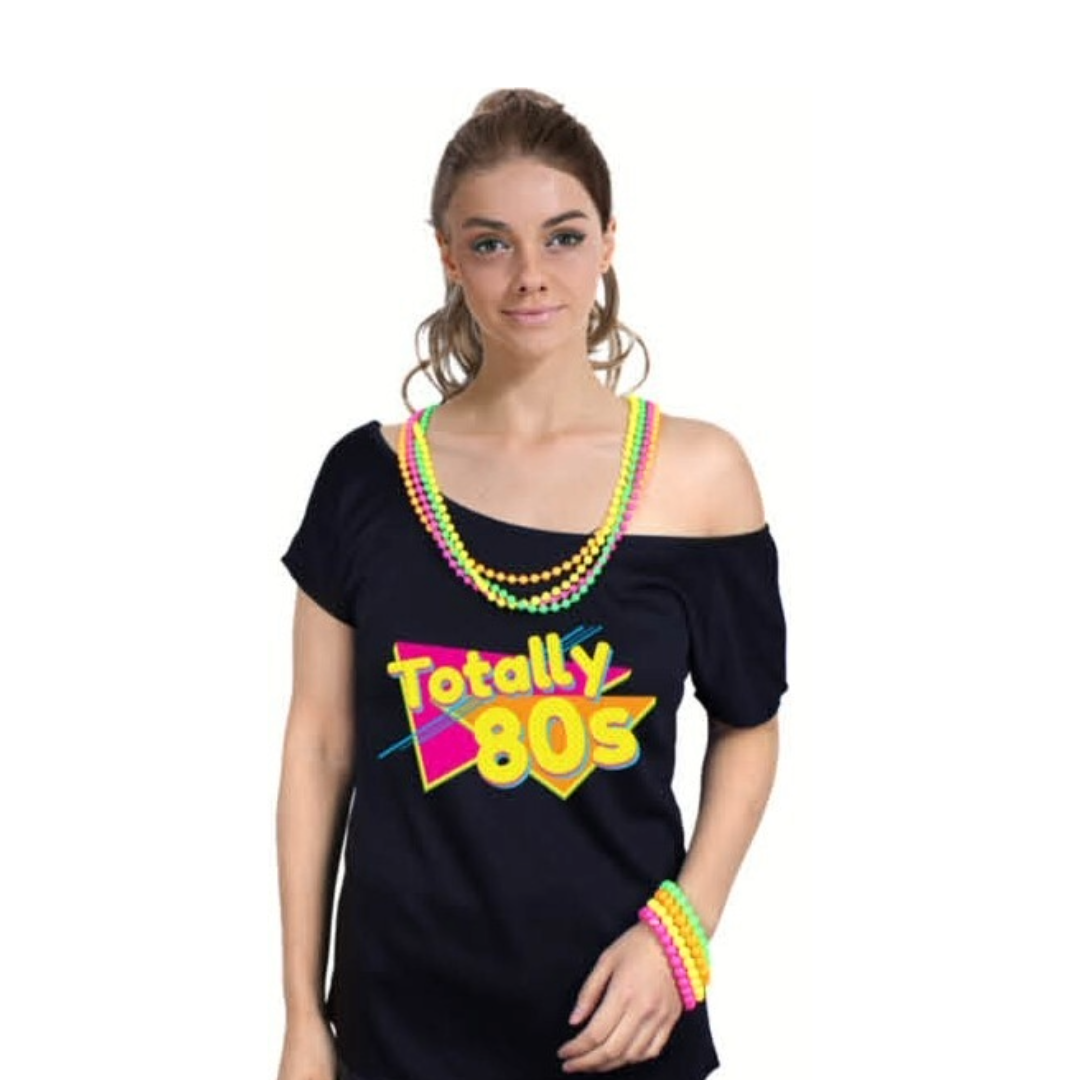 A woman wearing a 1980s Totally 80s Black Graphic T-Shirt Party Costume with colourful 1980s themed text and patterns. Accessorised with colourful wristbands and a neon-coloured beaded necklace.