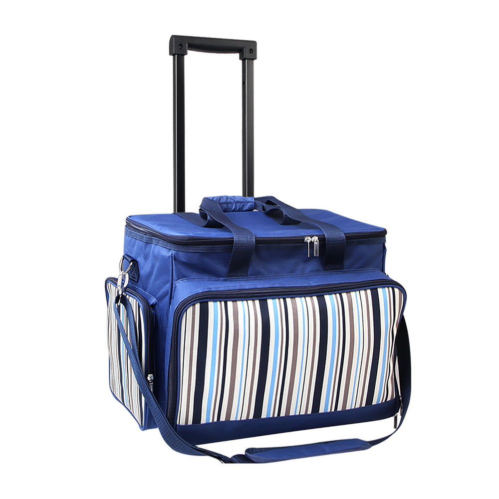 The Alfresco 6 Person Picnic Basket Set insulated picnic trolley in blue with a retractable handle and wheels, featuring a striped pattern on the front pocket and a carrying strap.