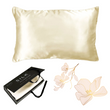 The Ardor Mulberry Silk Standard Pillowcase Ivory Dreams displayed alongside its packaging and a decorative flower, suggesting a luxurious and elegant product intended for comfort and style in bedroom decor.