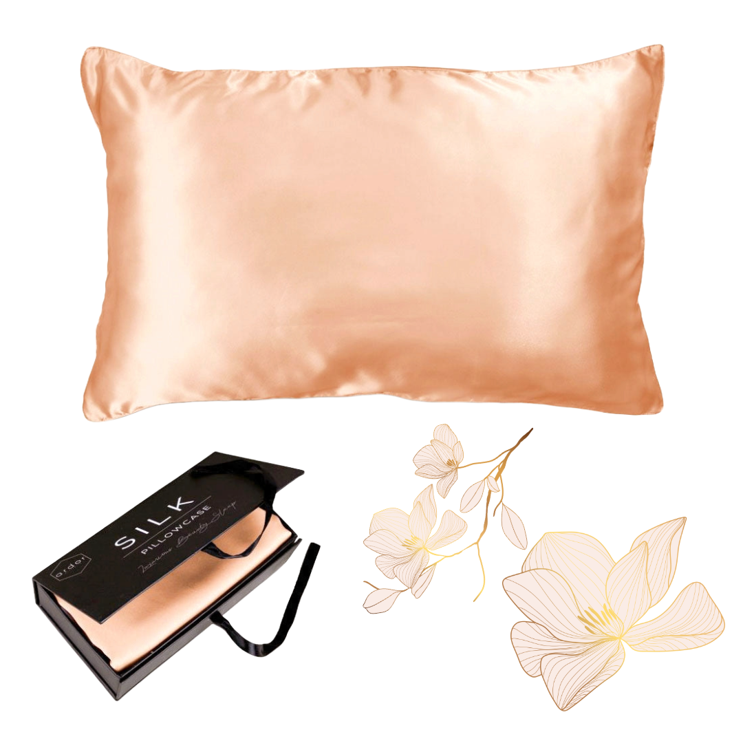The Ardor Mulberry Silk Standard Pillowcase Peach Spritz displayed alongside its packaging and a decorative flower, suggesting a luxurious and elegant product intended for comfort and style in bedroom decor.