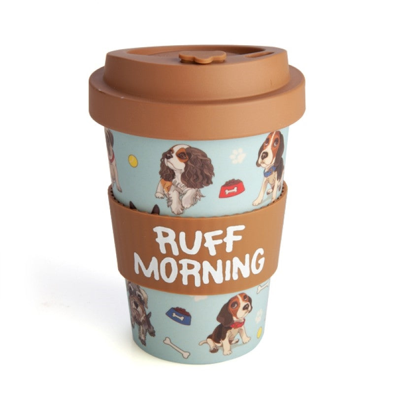 The Dogs Eco-to-Go Bamboo Travel Mug with a light blue background featuring a pattern of various cartoon dogs and the text 'Ruff Morning' on the front side, along with a matching brown lid.