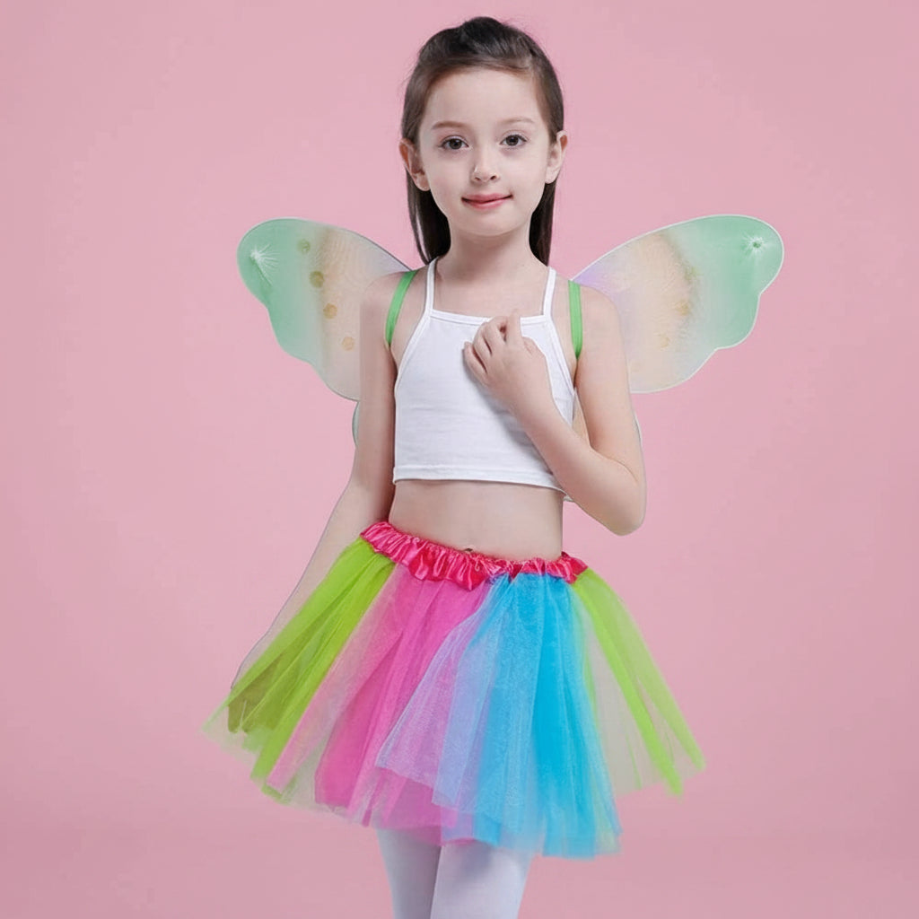 Young girl wearing colourful fairy wings and a rainbow tutu skirt on a baby pink background