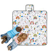 Two children are colouring on the Happy Kids Unicorn Dreams Colour Me In Picnic Blanket (125 x 125cm)