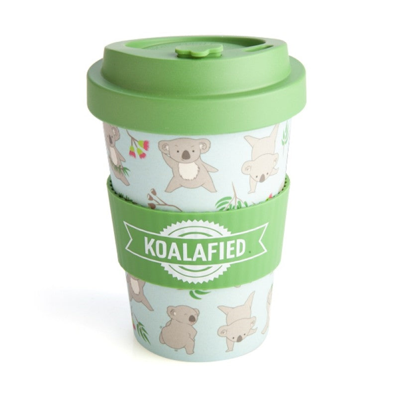 The Koala Eco-to-Go Bamboo Travel Mug with a green lid and matching silicone band, featuring a pattern of eucalyptus leaves and dancing koalas on a light blue background, with the word 'Koalafied' printed on the mug.