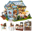 A Miniature Dollhouse with Furniture Kit plus Dust Proof and Music Movement - Rose Garden Tea House in blue with various furniture pieces and complete with led lights.