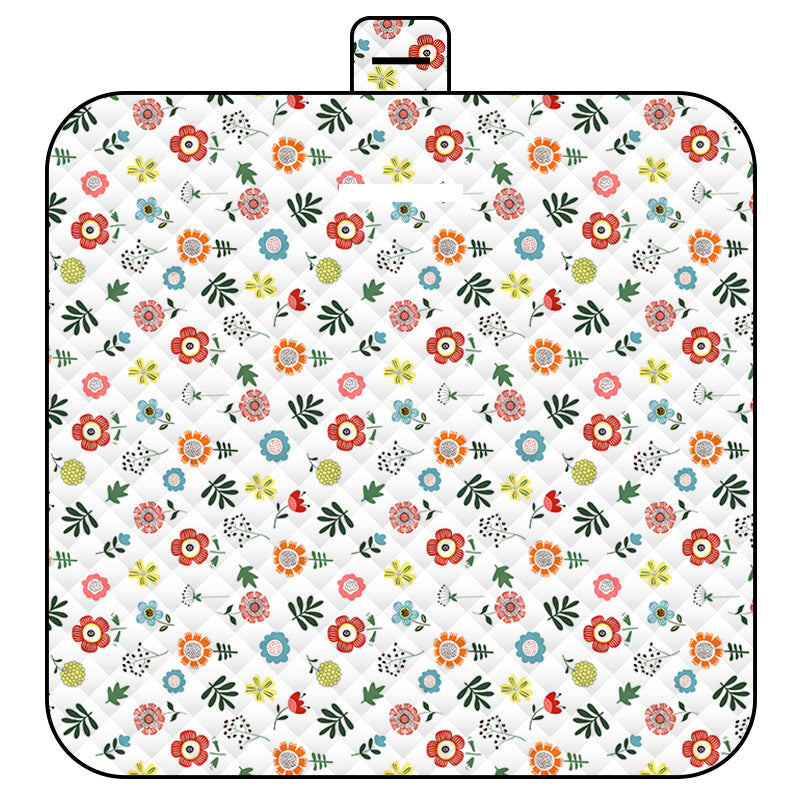 Floral patterned picnic mat with a handle on a white background