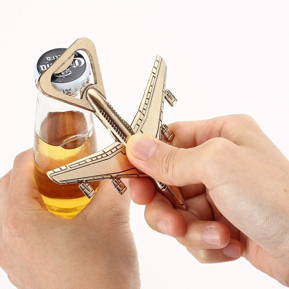 Airplane-shaped bottle opener being used on a glass of beer